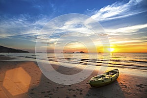 Canoe on the ocean beach during the amazing sunset.