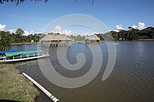 Canoe with tourists crosses the clean water lagoon El Milagro-loggon miracles-amazon jungle sky with clouds tingo maria peru-