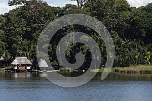 Canoe with tourists crosses the clean water lagoon El Milagro-loggon miracles-amazon jungle sky with clouds tingo maria peru-