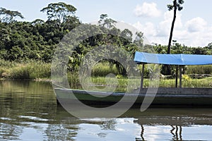 Canoe with tourists crosses the clean water lagoon El Milagro-loggon miracles-amazon jungle sky with clouds tingo maria peru-