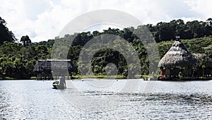 Canoe with tourists crosses the clean water lagoon El Milagro-loggon miracles-amazon jungle sky with clouds tingo maria peru-