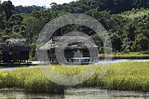 Canoe with tourists crosses the clean water lagoon El Milagro-loggon miracles-amazon jungle sky with clouds tingo maria peru-