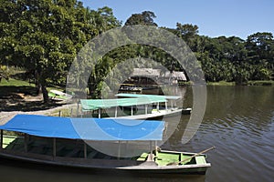 Canoe with tourists crosses the clean water lagoon El Milagro-loggon miracles-amazon jungle sky with clouds tingo maria peru-