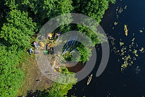 Canoes on the calm river and camp on the bank of the river. Top view. Beautiful picture of river and green banks of the river in