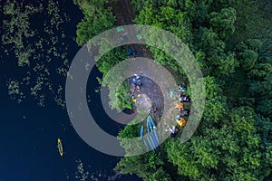 Canoes and camp on the bank of the river. Top view. Beautiful picture of river and green banks of the river in the summer morning