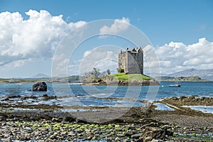 Canoes gathering at the historic castle Stalker in Argyll