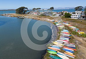 Canoes and kayaks line the shore, aerial image