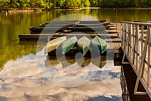 Canoes upside down on a dock on a lake