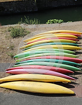 canoes of various colors on the river bank before training witho