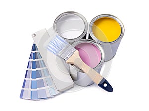Cans with different paints, brush and color palette on white background, top view