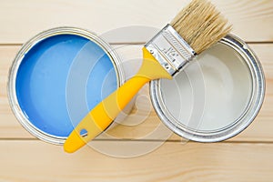 Cans of household paint and a paint brush