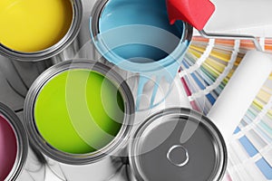 Cans of paints, roller and palette on white background, above view