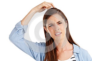 That cant be right...Studio shot of a beautiful young woman scratching her head in confusion against a white background.