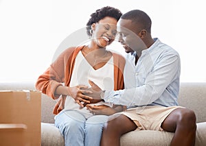 We cant hide our excitement. a young man touching his wifes pregnant belly at home.