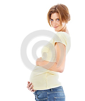 She cant wait. A young pregnant woman holding her stomach affectionately.