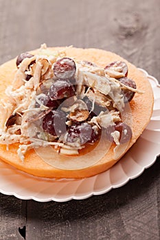 Cantaloupe with chicken grape salad on plate close up shot