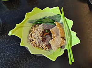 canton. chinese Chicken noodle on green leaf like bowl and chopstick photo