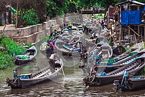 Inle Boat Station in Inle Nyaung Shwe Canal in Burma. A series of wooden fishing boats along the river generated by Inle Lake