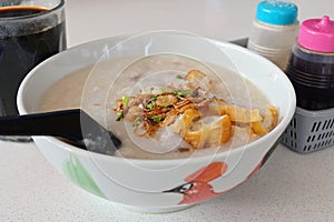 Cantonese Ting Zai porridge or congee, with a cup of traditional Nanyang black coffee, a breakfast comfort food in SE Asia