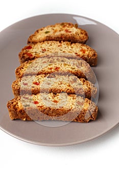 Cantucci cookies with candied fruit on brown plate