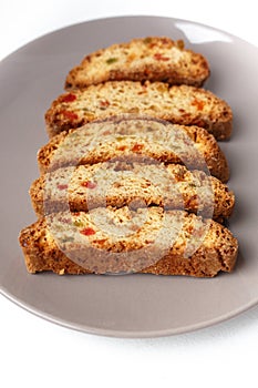 Cantucci cookies with candied fruit on brown plate