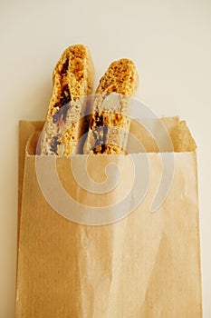 Cantucci cookies with candied fruits and nuts in a paper bag. White background