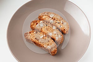 Cantucci cookies with nuts on brown plate