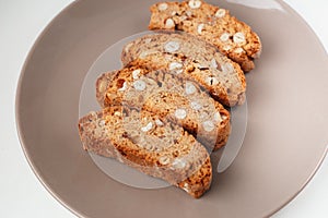 Cantucci cookies with nuts on brown plate