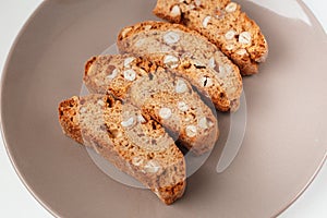 Cantucci cookies with nuts on brown plate
