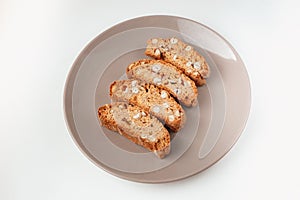 Cantucci cookies with nuts on brown plate