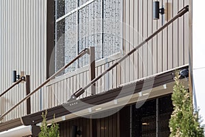 canvas awning with metal frame and drainage pipe against brown building. modern shading for house