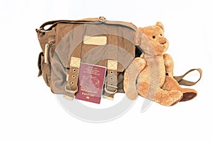 Canvas bag, British passport and teddy bear.