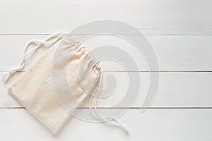 Canvas bag with drawstring, mockup of small eco sack made from natural cotton fabric cloth flat lay on white wood background