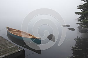 Canvas Cedar Canoe Tied to a Dock