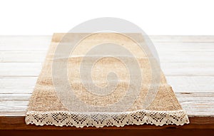 Canvas napkin with lace, tablecloth on wooden table on white background. Can used for display or montage your products