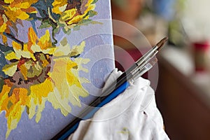 Canvas, paint, brushes, palette knife lying on the table.