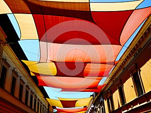 canvas patio awning. colorful fabric sun shade sail UV protection fabric suspended from exterior walls.