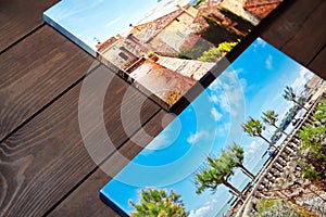 Canvas photo prints lying on a wooden table. Sample of gallery wrapping method of canvas stretching on stretcher bar. Side view of