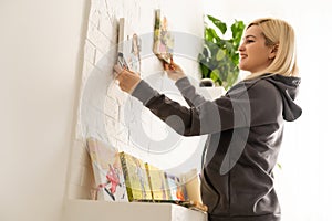 Canvas print. Photo of canvas stretching on stretcher bar. Woman hangs a color travel photography