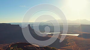 Canyonland desert area with sun rising and river in background in utah