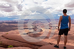Canyonlands - Man with scenic view of Split Mountain Canyon seen from Green River Overlook, Moab, Utah, USA