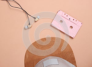 Cap, audio casset earphones on a brown background, music lover, minimalism, top view.