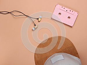 Cap, audio casset earphones on a brown background, music lover, minimalism, top view.