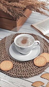 Cap of coffee and cookies on wicker jute placemat