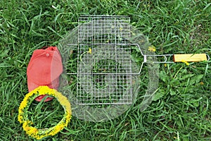 Cap and grill on green grass. picnic items