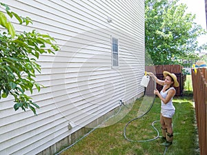 Capable fit woman spraying down house sidings