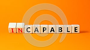 Capable or incapable symbol. Concept words Capable or Incapable on wooden cubes. Beautiful orange table orange background.