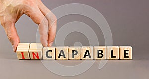 Capable or incapable symbol. Concept words Capable or Incapable on wooden cubes. Businessman hand. Beautiful grey table grey