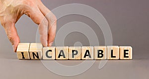 Capable or incapable symbol. Concept words Capable or Incapable on wooden cubes. Businessman hand. Beautiful grey table grey
