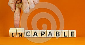 Capable or incapable symbol. Concept words Capable or Incapable on wooden cubes. Businessman hand. Beautiful orange table orange